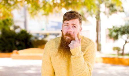 Photo for Red hair bearded man looking desperate and frustrated, sad, unhappy and crying - Royalty Free Image