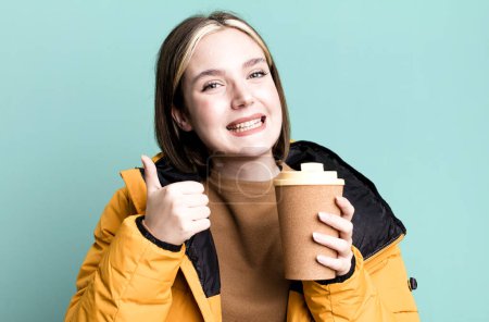 Téléchargez les photos : Jeune jolie femme avec un manteau et un café à emporter - en image libre de droit