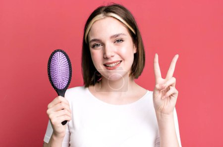 Téléchargez les photos : Young pretty woman using a hair comb - en image libre de droit