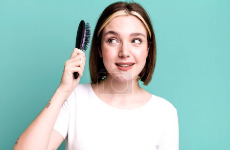 Téléchargez les photos : Young pretty woman using a hair comb - en image libre de droit
