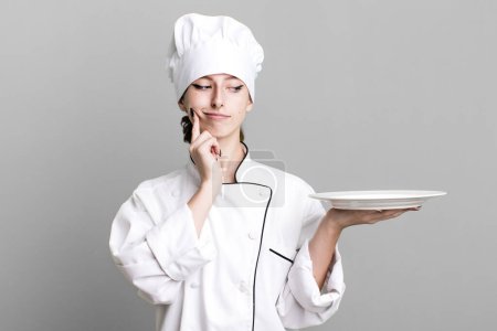 Foto de Caucasian pretty blonde woman. chef with a dish concept - Imagen libre de derechos