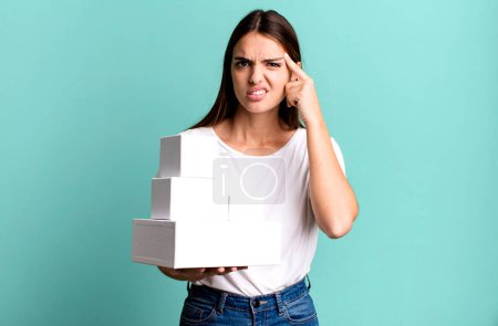 Foto de Joven bonita mujer sintiéndose confundido y perplejo, mostrando que está loco. cajas blancas en blanco - Imagen libre de derechos