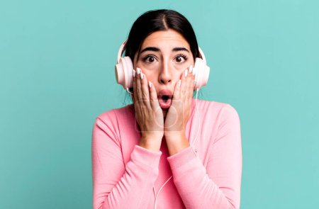 Photo for Feeling shocked and scared. listening music with headphones - Royalty Free Image