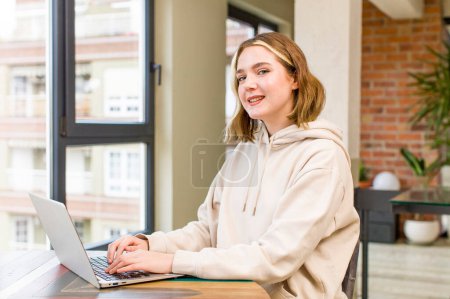 Téléchargez les photos : Jolie jeune femme avec un ordinateur portable travaillant à la maison. design intérieur de la maison - en image libre de droit