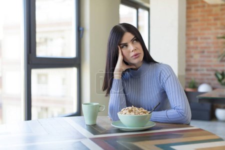 Photo for Pretty young woman feeling bored, frustrated and sleepy after a tiresome. breakfast concept - Royalty Free Image