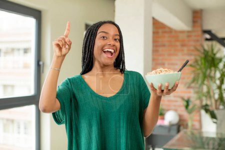 Foto de Negro afro mujer sintiéndose como un feliz y emocionado genio después de darse cuenta de una idea. concepto de plato de desayuno - Imagen libre de derechos