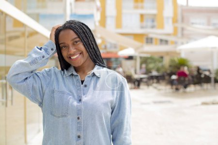 Téléchargez les photos : Afro jolie femme noire souriant joyeusement et occasionnellement, prenant main dans la main avec un regard positif, heureux et confiant - en image libre de droit