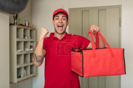 Photo for Young handsome man feeling shocked,laughing and celebrating success. pizza delivery concept - Royalty Free Image