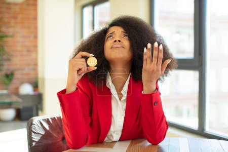 Foto de Mujer negra bastante afro gritando con las manos arriba en el aire. concepto de moneda virtual - Imagen libre de derechos
