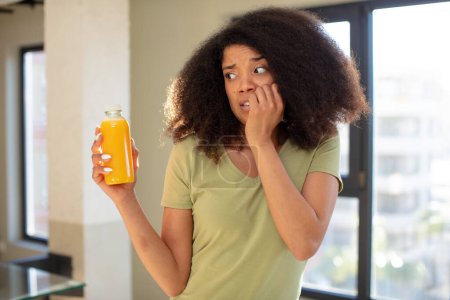 Foto de Mujer negra bastante afro sentirse asustado, preocupado o enojado y mirando a un lado. concepto de zumo de naranja - Imagen libre de derechos