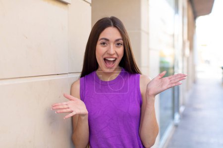 Téléchargez les photos : Jeune jolie femme se sentant heureuse, excitée, surprise ou choquée, souriante et étonnée de quelque chose d'incroyable - en image libre de droit
