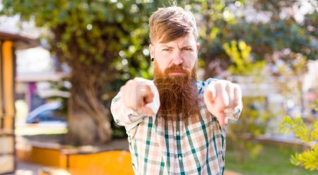 Photo for Red hair bearded man pointing forward at camera with both fingers and angry expression, telling you to do your duty - Royalty Free Image