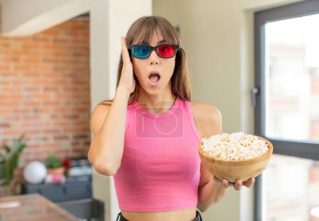 Photo for Young pretty woman feeling extremely shocked and surprised. popcorns movie concept - Royalty Free Image