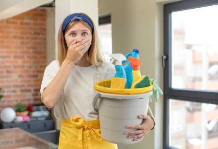 Photo for Young pretty woman covering mouth with a hand and shocked or surprised expression. house keeper and clean product concept - Royalty Free Image