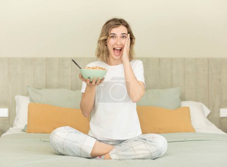 Photo for Pretty woman feeling happy and astonished at something unbelievable. breakfast bowl - Royalty Free Image