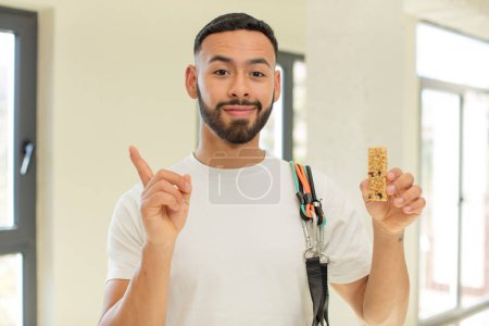 Photo for Arab handsome man arab man smiling cheerfully, feeling happy and pointing to the side.  fitness and cereal bar concept - Royalty Free Image