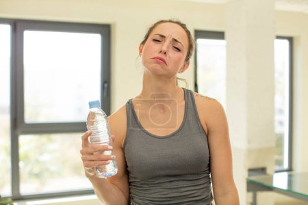 Photo for Pretty woman feeling sad and whiney with an unhappy look and crying. water bottle concept - Royalty Free Image
