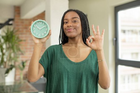 Téléchargez les photos : Femme afro noire se sentant heureuse, montrant son approbation avec un geste correct. concept de réveil - en image libre de droit