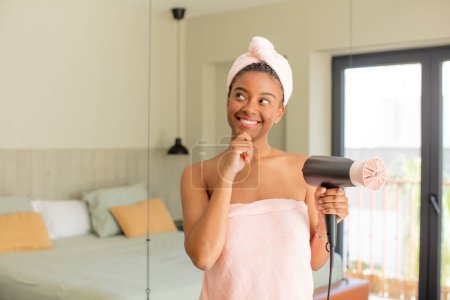 Téléchargez les photos : Noir afro femme souriant avec une expression heureuse et confiante avec la main sur le menton. concept de sèche-cheveux - en image libre de droit