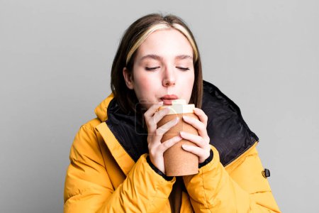 Foto de Joven bonita mujer con un abrigo y un café para llevar - Imagen libre de derechos