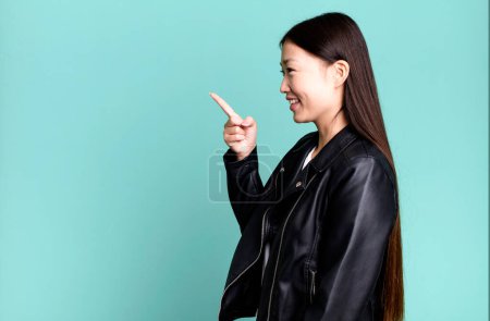Téléchargez les photos : Young adult pretty asian expressive woman with a copy space to the side - en image libre de droit