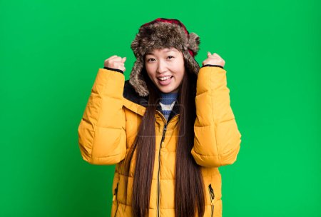 Téléchargez les photos : Young adult pretty asian woman wearing anorak and winter hat - en image libre de droit