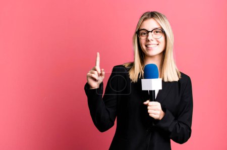Téléchargez les photos : Jeune jolie journaliste ou présentatrice femme avec un microphone - en image libre de droit
