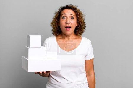 Foto de Mujer bastante mediana edad que parece muy sorprendido o sorprendido. cajas blancas en blanco embalaje - Imagen libre de derechos
