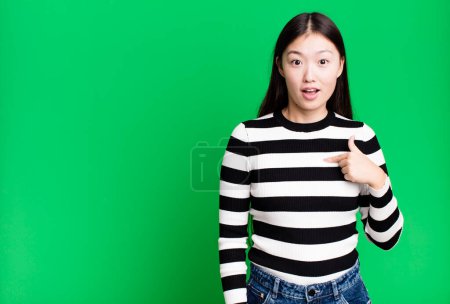 Foto de Bastante asiática mujer buscando sorprendido y sorprendido con boca abierta, apuntando a sí mismo - Imagen libre de derechos