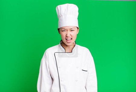 Photo for Pretty asian woman shouting aggressively, looking very angry. restaurant chef concept - Royalty Free Image