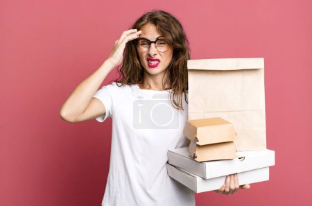 Foto de Mujer bonita hispana sintiéndose confundida y perpleja, mostrando que estás loca. quitar concepto de paquetes de comida rápida - Imagen libre de derechos