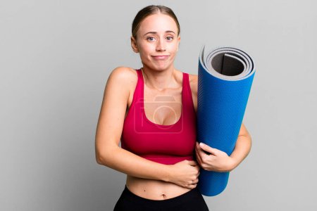 Photo for Caucasian pretty woman shrugging, feeling confused and uncertain. fitness and yoga concept - Royalty Free Image