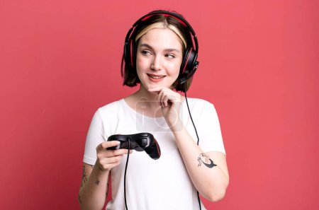 Photo for Young pretty woman smiling with a happy, confident expression with hand on chin. gamer concept - Royalty Free Image