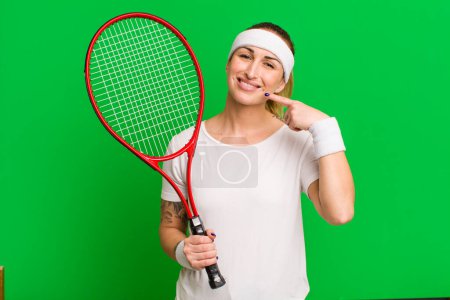 Téléchargez les photos : Jeune jolie femme souriante pointant avec confiance à son propre sourire large. concept de tennis - en image libre de droit