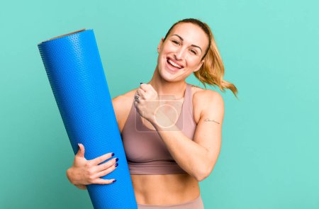 Téléchargez les photos : Young pretty woman feeling happy and facing a challenge or celebrating. fitness and yoga concept - en image libre de droit