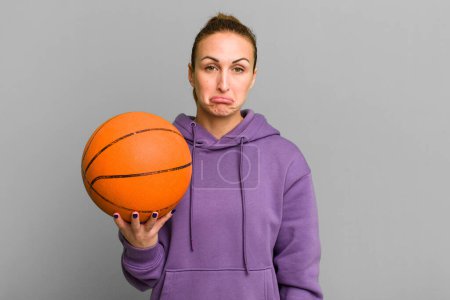 Foto de Joven bonita mujer sintiéndose triste y llorona con una mirada infeliz y llorando. concepto de baloncesto - Imagen libre de derechos