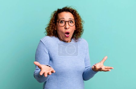 Photo for Middle age hispanic woman open-mouthed and amazed, shocked and astonished with an unbelievable surprise - Royalty Free Image
