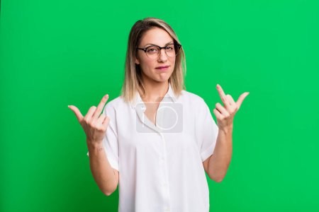 Foto de Mujer adulta rubia sintiéndose provocativa, agresiva y obscena, volteando el dedo medio, con una actitud rebelde - Imagen libre de derechos