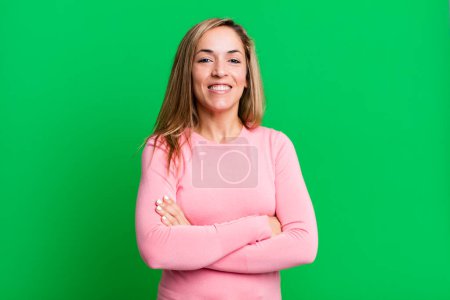 Foto de Rubia mujer adulta que parece una feliz, orgullosa y satisfecha triunfadora sonriendo con los brazos cruzados - Imagen libre de derechos