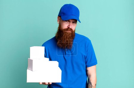 Foto de Joven adulto pelo rojo barbudo fresco entrega hombre con cajas - Imagen libre de derechos