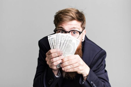 Photo for Young adult red hair bearded cool businessman with dollarbanknotes - Royalty Free Image