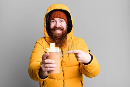 Téléchargez les photos : Longue barbe et cheveux roux homme cool portant chapeau et manteau. concept froid et hiver - en image libre de droit