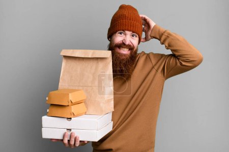 Foto de Barba larga y cabello rojo hombre fresco. entrega y comida para llevar concepto - Imagen libre de derechos