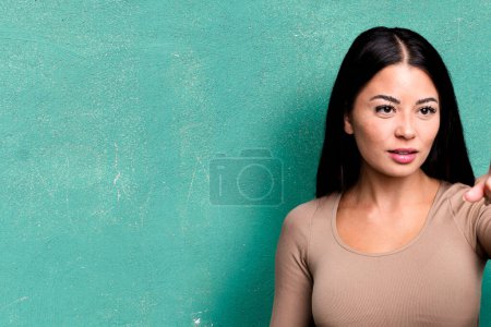 Photo for Hispanic pretty woman smiling and looking happy, gesturing victory or peace. business concept - Royalty Free Image