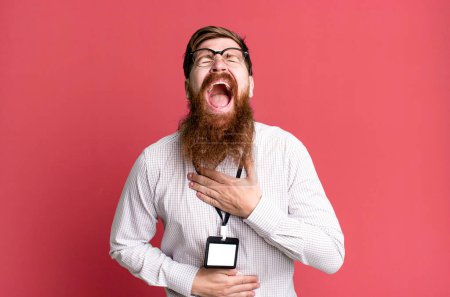 Téléchargez les photos : Long homme barbe riant à haute voix à une blague hilarante. vip badge concept d'accréditation - en image libre de droit