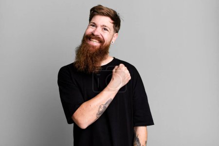 Téléchargez les photos : Barbe longue et cheveux roux homme se sentir heureux et faire face à un défi ou célébrer - en image libre de droit