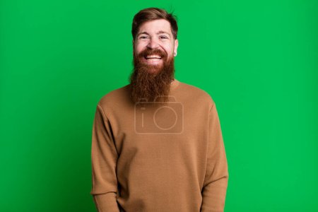 Foto de Barba larga y pelo rojo hombre buscando feliz y gratamente sorprendido - Imagen libre de derechos