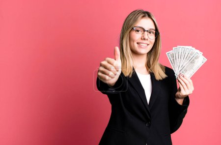 Photo for Young pretty woman feeling proud,smiling positively with thumbs up. business and money concept - Royalty Free Image