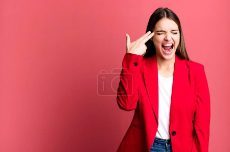 Photo for Young pretty woman looking unhappy and stressed, suicide gesture making gun sign. businesswoman concept - Royalty Free Image