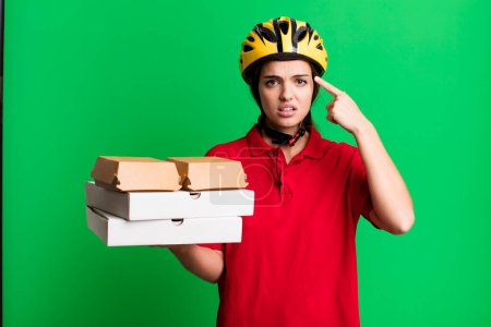 Photo for Young pretty woman feeling confused and puzzled, showing you are insane. pizza delivery concept - Royalty Free Image